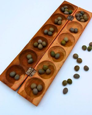 El awalé africano se juega con una tabla de madera y semillas o piedras pequeñas.