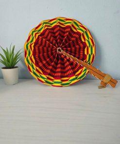Abanico Kente Sol artesanal con tela wax africana en tonos amarillos, naranjas y dorados, con mango de madera y detalles en cuero.