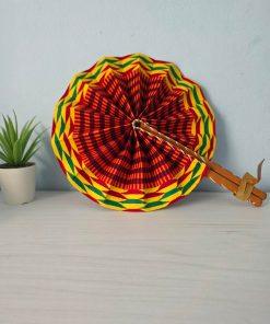 Abanico Kente Sol artesanal con tela wax africana en tonos amarillos, naranjas y dorados, con mango de madera y detalles en cuero.